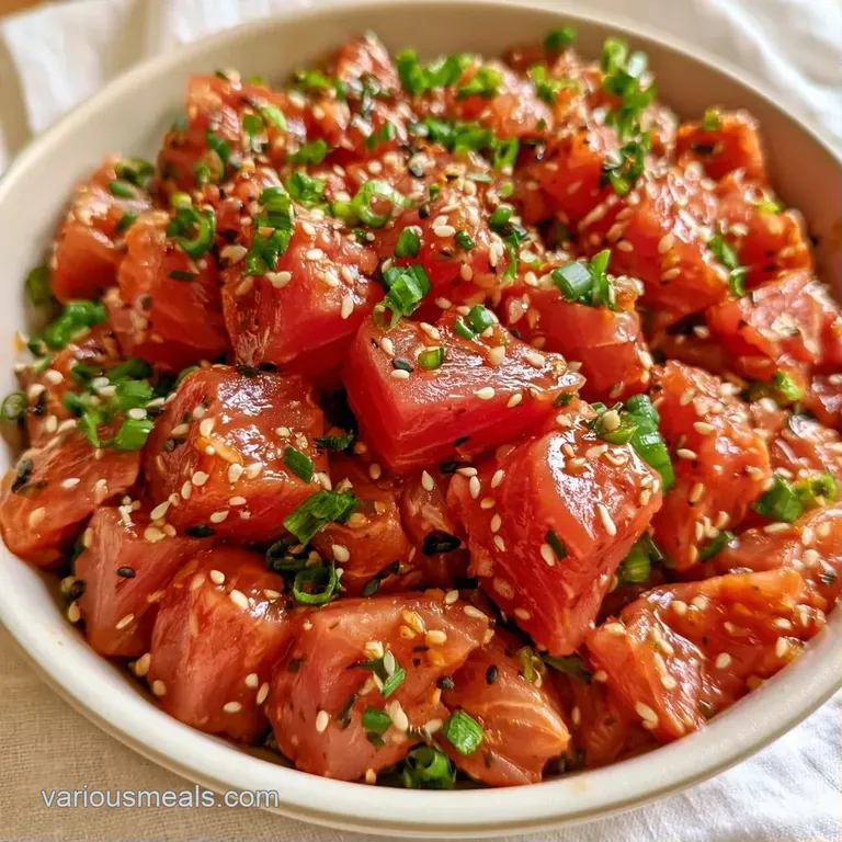 Vibrant bowl of cubed raw tuna and avocado topped with sesame seeds, served in a modern ceramic bowl on a light table.