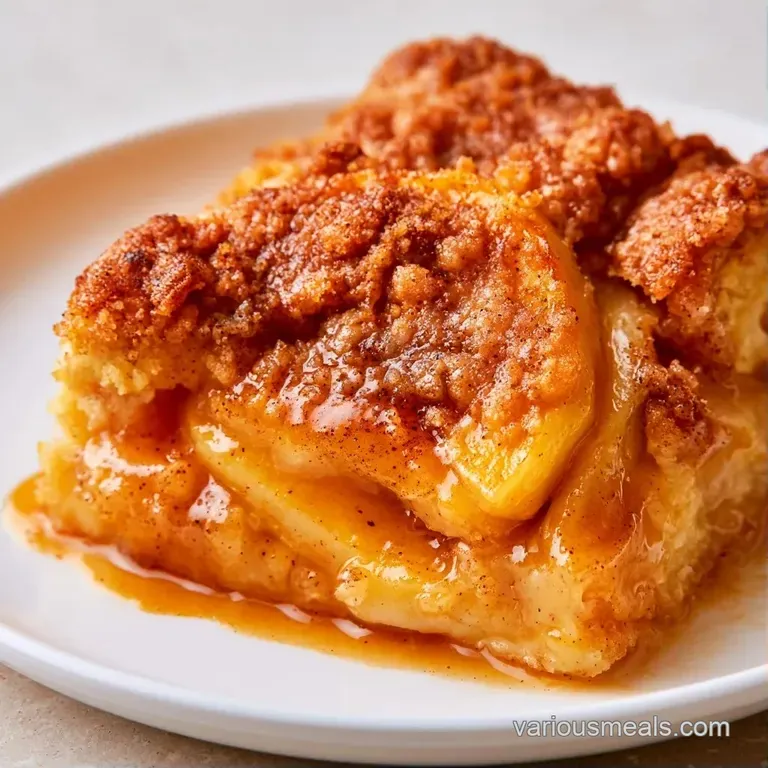 A square slice of moist cinnamon cake on a ceramic plate, drizzled with vanilla glaze and a mint leaf garnish.