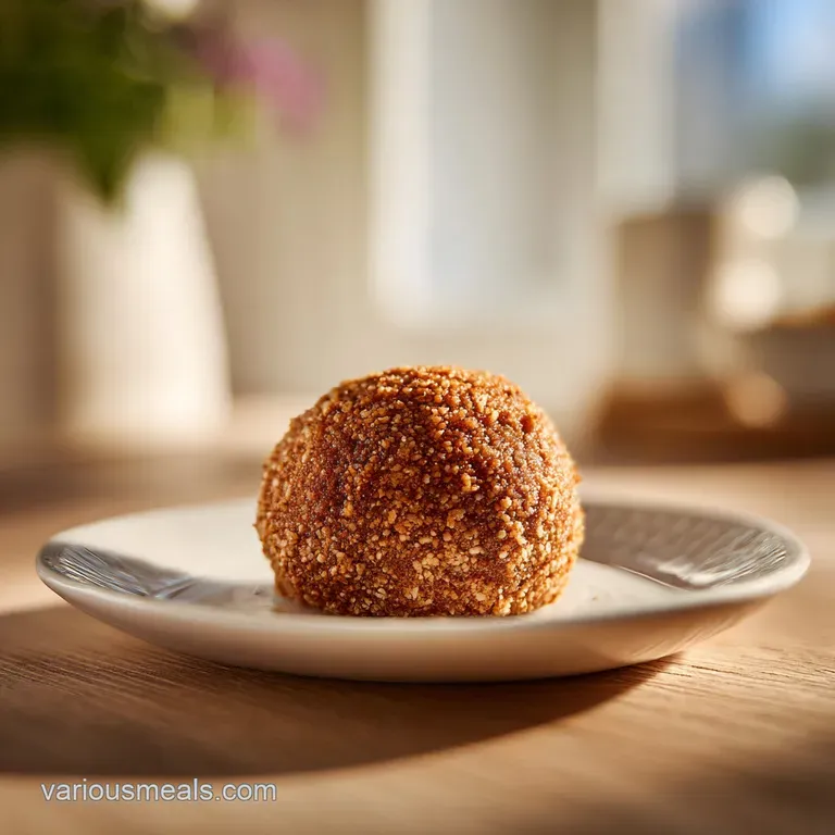 A beautifully plated dish of plump meatballs coated in smooth, savory gravy with a sprinkle of herbs.