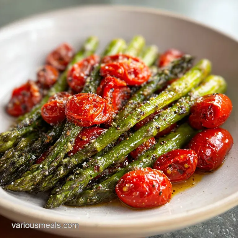 Plated roasted asparagus and tomatoes glistening with balsamic glaze, sprinkled with parmesan and herbs, ready to eat.