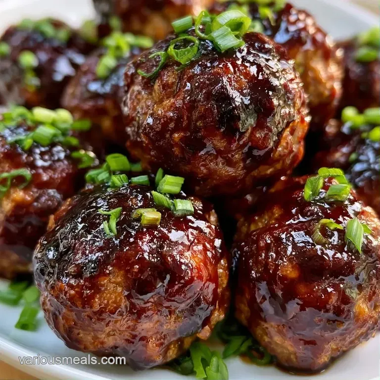 Three glossy brown spheres arranged on a dark slate platter, garnished with fresh parsley and a drizzle of sauce.