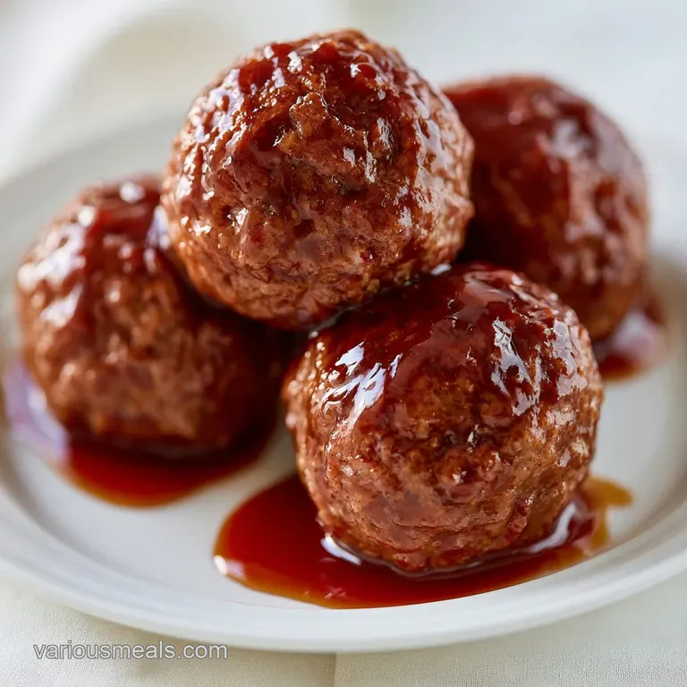 Platter of sticky mahogany-colored meatballs on a white dish, each topped with a toothpick and a sprig of fresh green herb.