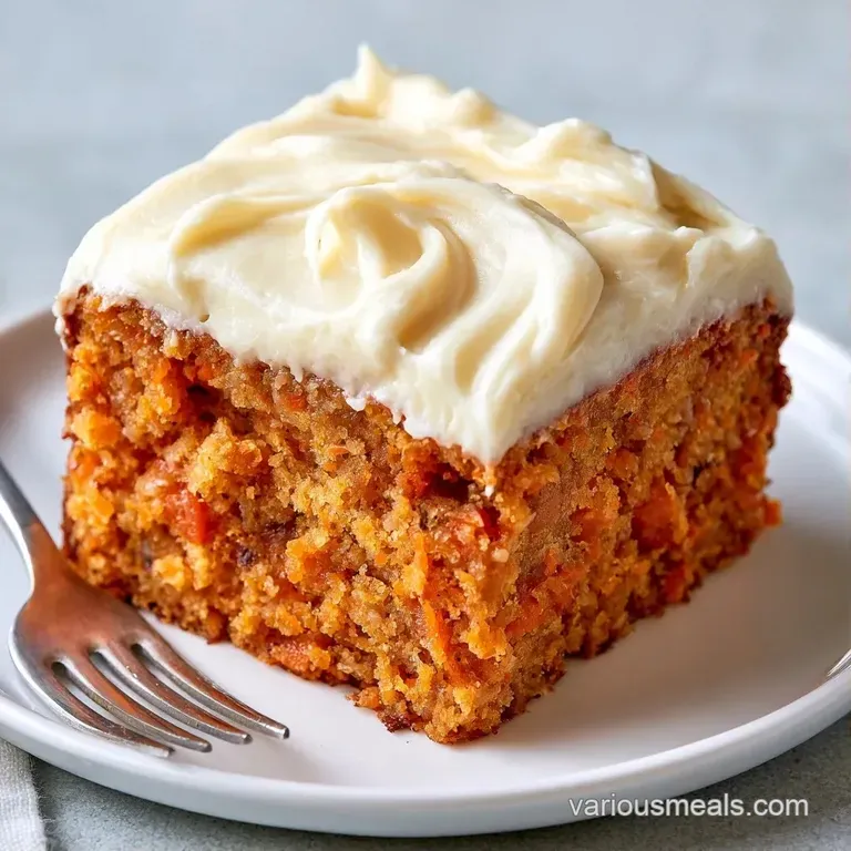 A precise slice of spiced orange cake with white frosting on a marble plate, garnished with a small mint leaf.