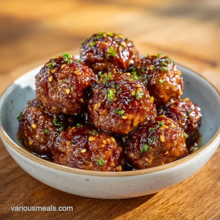 Plump, glazed protein spheres arranged on a minimalist white platter with a sprinkle of fresh green scallions.