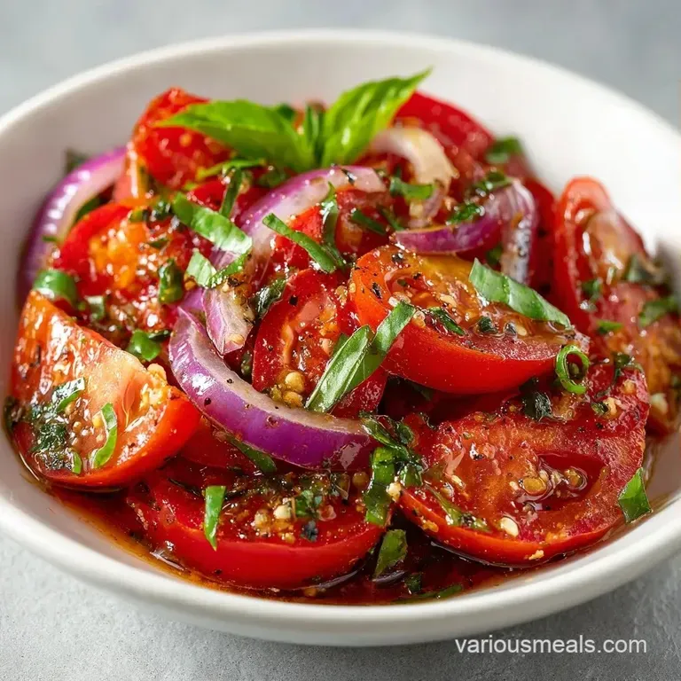 Thinly sliced heirloom tomatoes arranged in a circle with bright basil leaves and a dark, syrupy balsamic glaze.