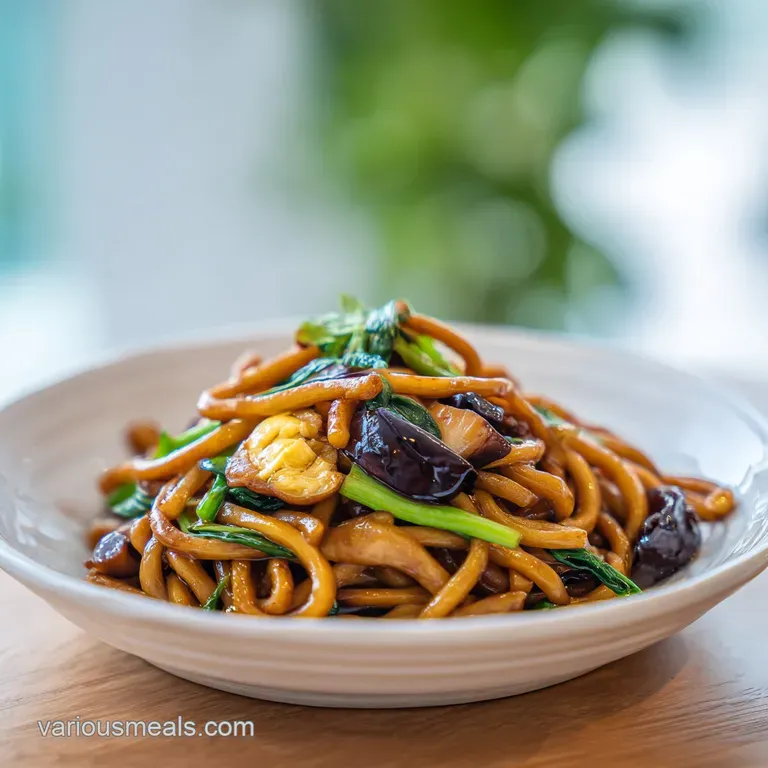 A mound of glossy, fried noodles served in a white bowl, garnished with fresh green onions and sesame seeds, hinting at sa...