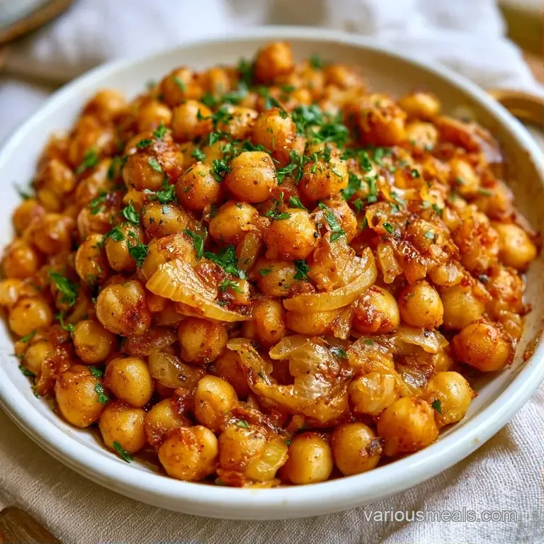Vibrant chickpea mix with creamy feta and sliced olives served in a matte bowl beside a wedge of fresh yellow lemon