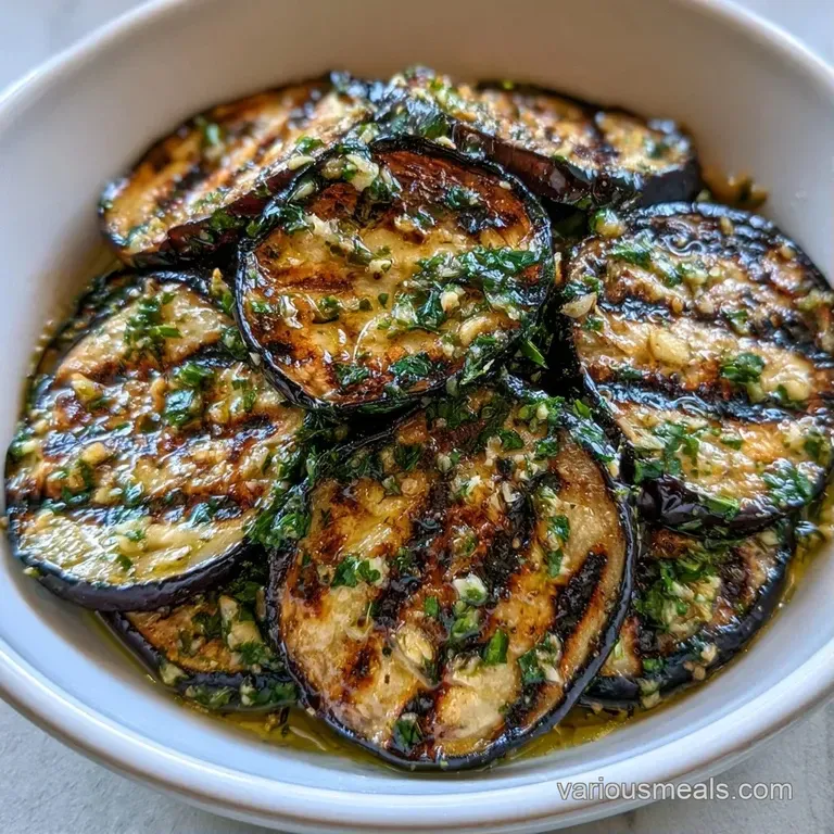 Charred purple vegetable slices topped with fresh parsley and a bright lemon wedge on a white ceramic plate.