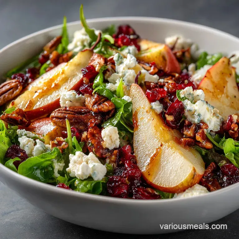 Elegant pear salad on a white plate, showcasing crisp greens, juicy pear slices, crumbled cheese, and glistening balsamic ...