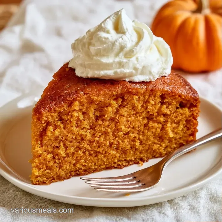 An elegant slice of golden-orange cake paired with a peak of white cream on a marble surface with a gold fork.