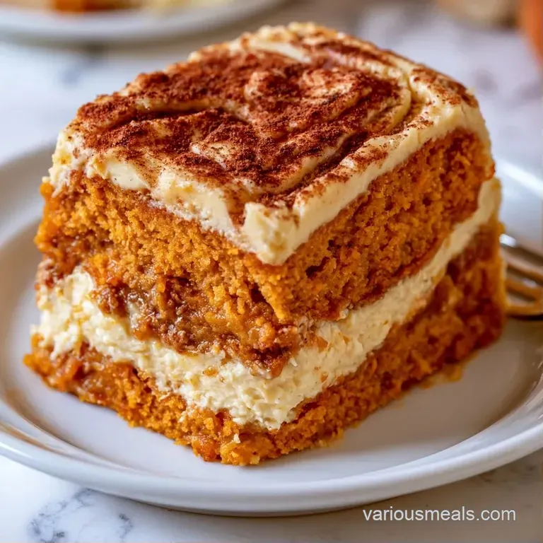A slice of orange and white layered cake topped with a dollop of cream and a pinch of cinnamon on a gold plate.