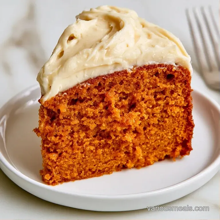 A thin slice of orange spice cake on a white ceramic plate, paired with a dollop of whipped cream and a mint leaf