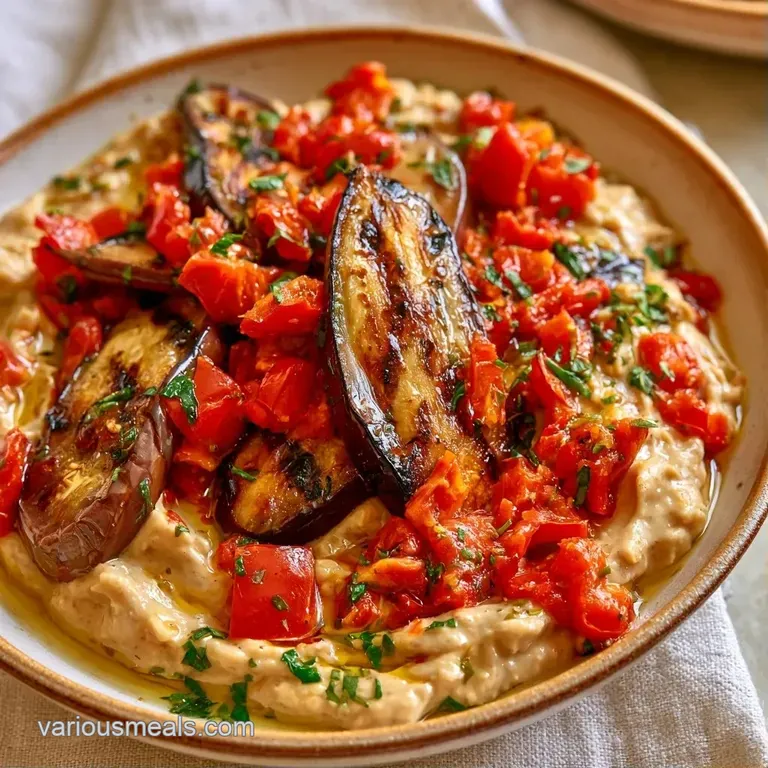 Velvety beige dip in a stone bowl, garnished with paprika and surrounded by warm, charred pita bread slices.