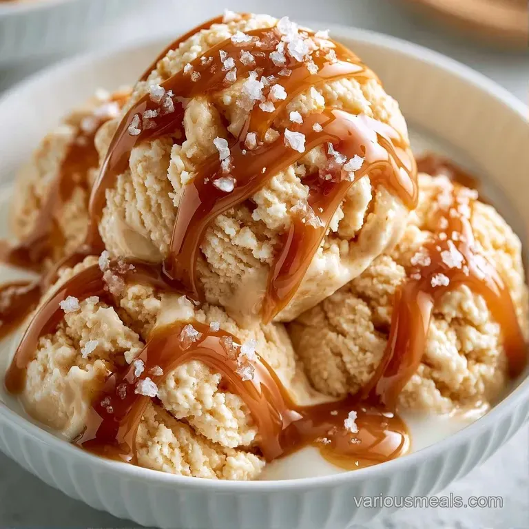Smooth frozen cream in a white bowl with drizzled honey and toasted almond slivers on a light marble surface.