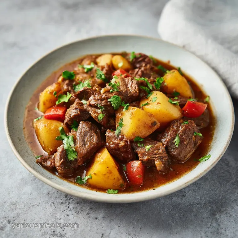 A glistening bowl of lamb stew, topped with fresh parsley, beside crusty bread for dipping.