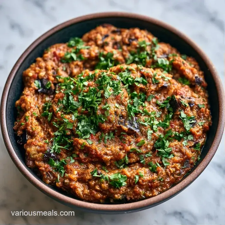Rustic bowl of mashed charred eggplant topped with cilantro, served with warm, buttery garlic naan on the side